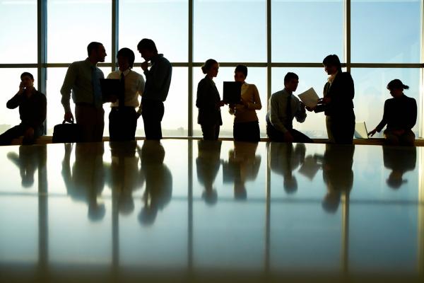 Business meeting in brightly lit glassed conference room