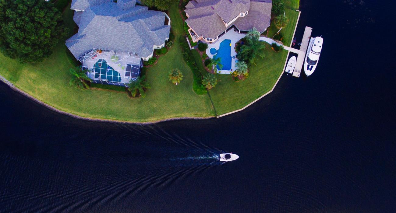 Aerial view of two mansions and a yacht
