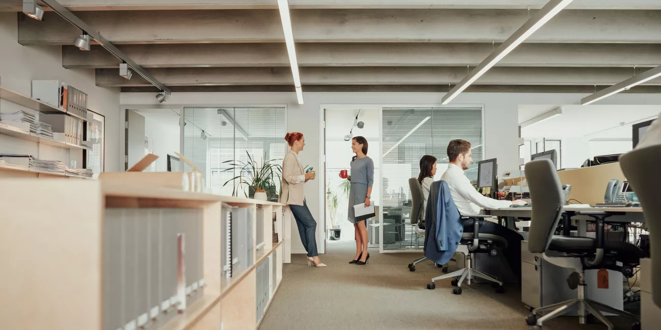 Two women talking in an open office